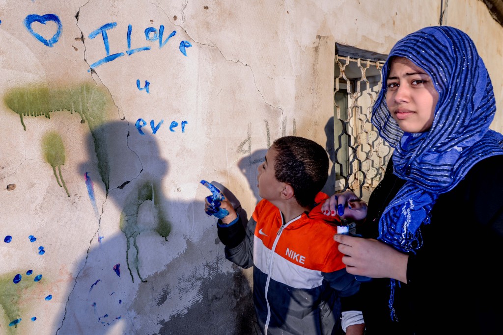 A girl and her little brother decorate a wall in Lod. Photo: Aviram Valdman