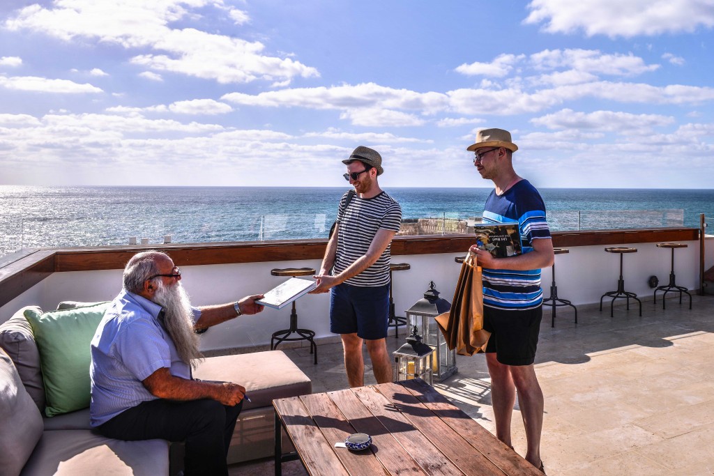 Famed seafood restaurateur Uri Jeremias chats with vacationers. Photo: Aviram Valdman / The Tower