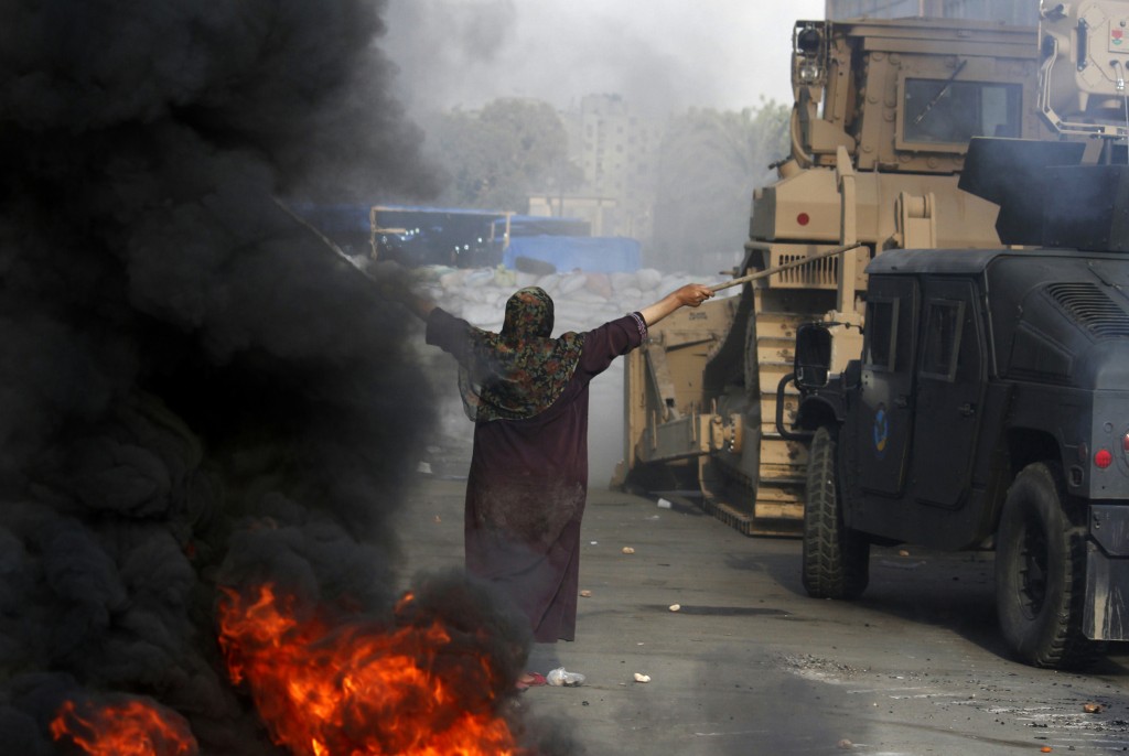 An Egyptian woman tries to stop a military bulldozer from going forward during clashes that broke out as Egyptian security forces moved in to disperse supporters of Egypt's deposed president Mohamed Morsi in a huge protest camp near Rabaa al-Adawiya mosque in eastern Cairo on August 14, 2013. The operation began shortly after dawn when security forces surrounded the sprawling Rabaa al-Adawiya camp in east Cairo and a similar one at Al-Nahda square, in the centre of the capital, launching a long-threatened crackdown that left dozens dead. Photo: AFP/Mohammed Abdel Moneim / flickr