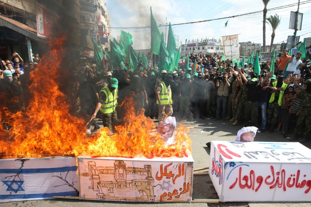 Hamas militants burn a coffin draped in an Israeli flag, during a rally marking the 13th anniversary of Second Intifada', in central Gaza Strip, 27 September 2013. Photo: Abed Rahim Khatib/Flash90