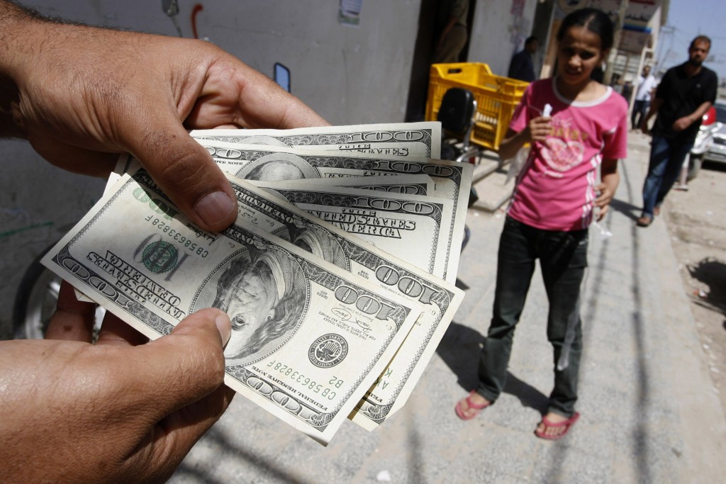 Palestinian man employed by the authority of Mahmoud Abbas' Fatah displays the money after withdrawn by ATM at the Bank of Palestine in Rafah, southern Gaza Strip on June 8, 2012, Photo Abed Rahim Khatib / Flash 90