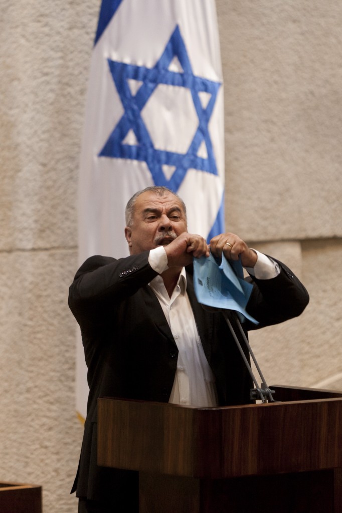 Knesset Member Mohammad Barakeh of the Hadash party tears the Prawer Plan during a plenum meeting in the Knesset, in Jerusalem, June 24, 2013. Arab Knesset members left the plenum Monday evening in protest. Photo: Flash 90