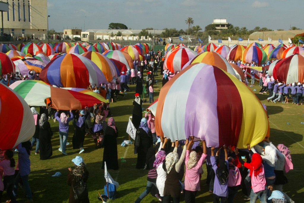 Palestinian children perform with parachutes during summer camp activities supervised by UNRWA in Khan Yunis in the southern Gaza Strip, June 30, 2011. They attempted to break the Guinness world record for most parachutes bounced simultaneously. Photo by Abed Rahim Khatib / Flash90