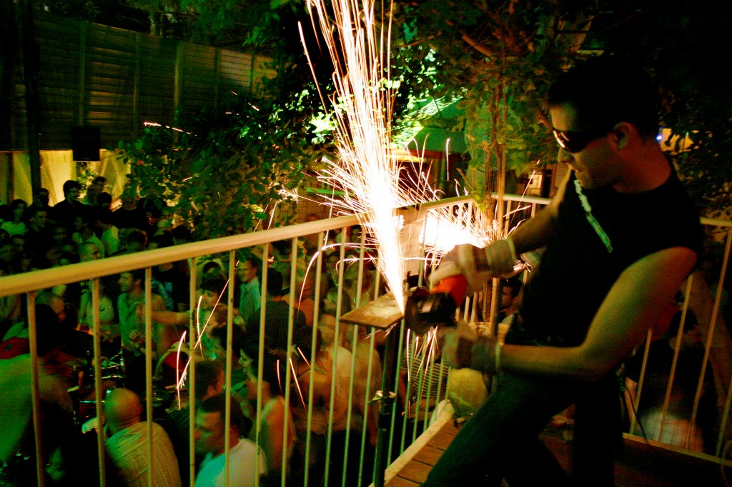 A man uses a buzzsaw to create sparks at the opening party for Blend, a nightclub in Tel Aviv. Photo: Melanie Fidler / Flash90