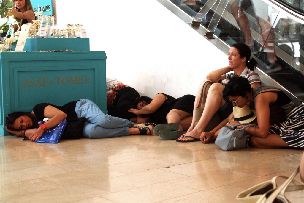 Israelis take cover at the Dizengoff Center mall in Tel Aviv as sirens alert to incoming rockets from Gaza. Photo: Roni Schutzer / Flash90