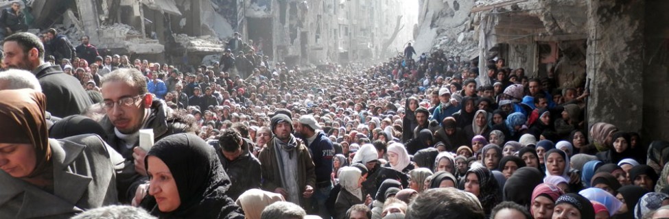 Residents of the Yarmouk refugee camp line up for aid distributed by UNRWA, February 2014. Photo: Rami Al Sayyed / UNRWA / flickr