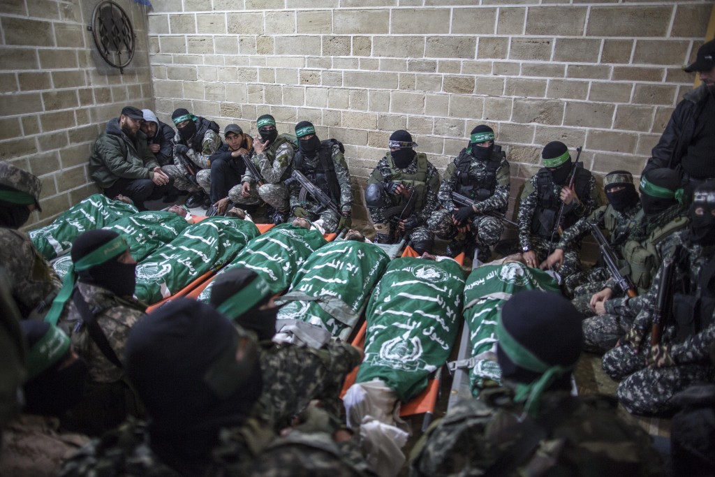 Members of the Izz ad-Din al-Qassam Brigades, Hamas’ militia, pray near the bodies of seven members who were killed while repairing a tunnel, January 29, 2016. Photo: Emad Nassar / Flash90