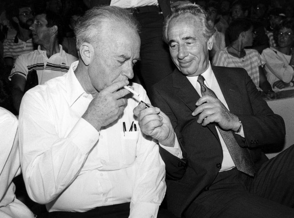 Prime Minister Shimon Peres lights the cigarette of Defense Minister Yitzhak Rabin, September 16, 1986. Photo: Moshe Shai / Flash90