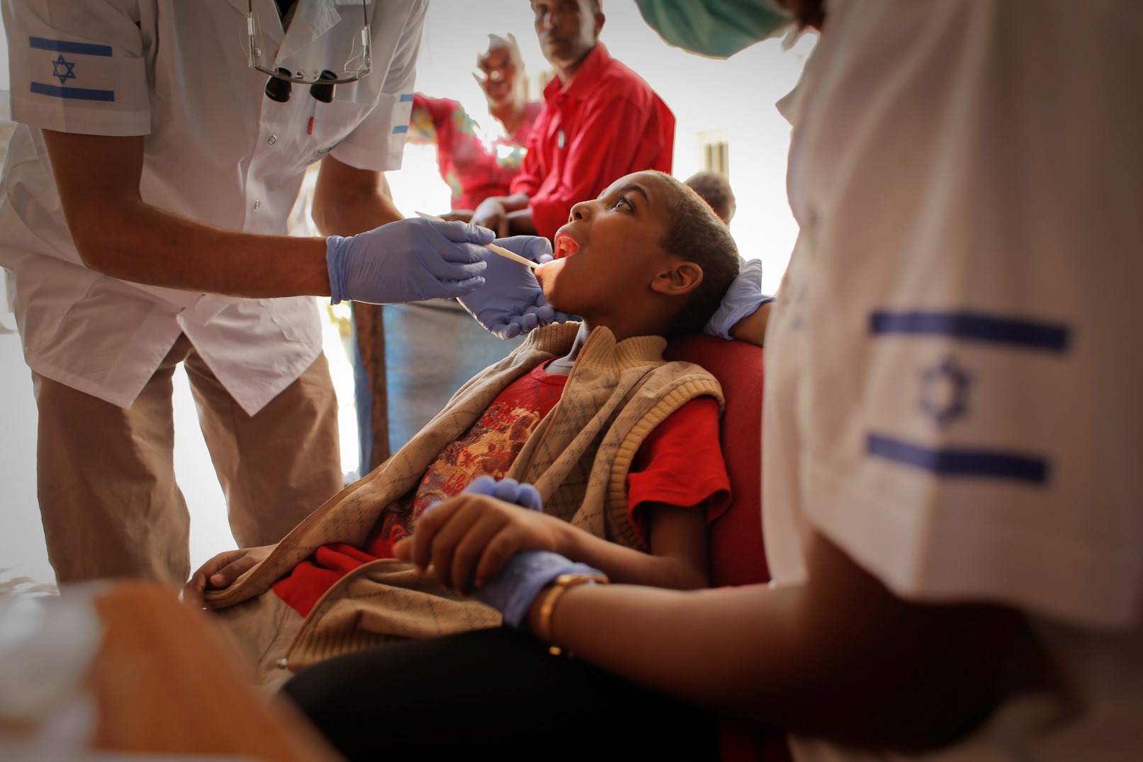 An Israeli dentist and post-army volunteer caring for a child in Ethiopia. Photo courtesy of FFL