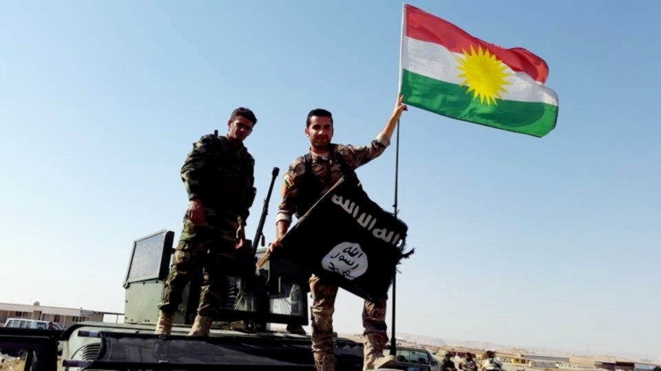 Peshmerga near Mosul remove the Islamic State flag and replace it with the Kurdish flag. Photo: Kurdish Struggle / flickr
