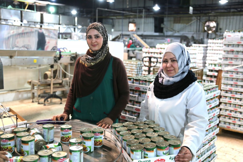 Anood from Jordan and Salma from Syria, working together in a Syrian-owned food processing factory in Jordan. Photo: Bea Arscott / UK Department for International Development