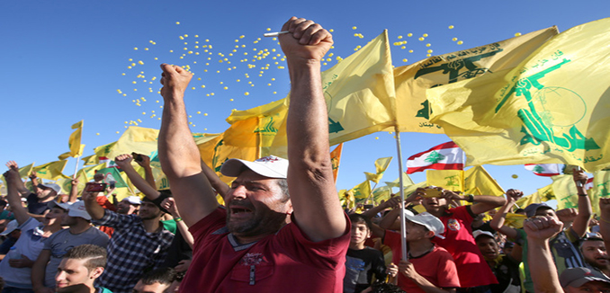 Hezbollah supporters shout slogans and wave Hezbollah flags, during a rally commemorating "Liberation Day" which marks the withdrawal of the Israeli army from southern Lebanon in 2000, in the southern border town of Bint Jbeil, Lebanon, Sunday May 25, 2014. Hezbollah's leader Sheik Hassan Nasrallah is warning that hard-line foreign fighters in Syria pose a global threat as they return home. Nasrallah accused European countries of easing the flight of extremist fighters into Syria, where they are fighting against the rule of President Bashar Assad. (AP Photo/Hussein Malla)